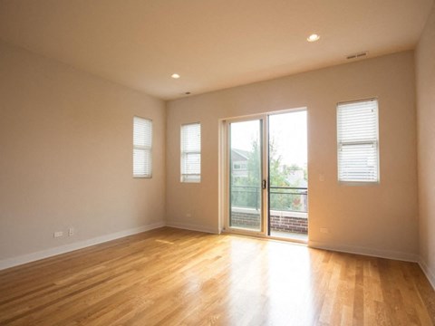 a living room with a wood floor and a glass door