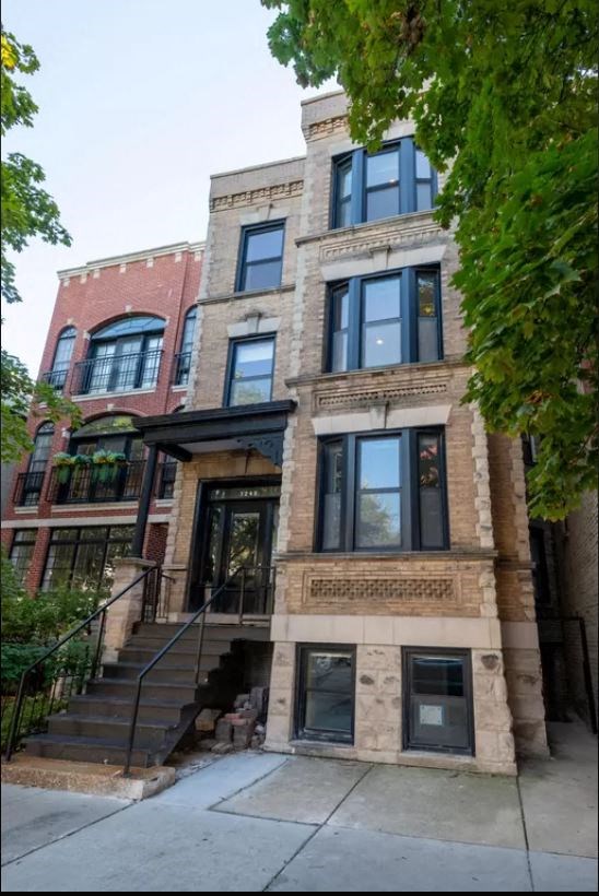 the front of a brick building with stairs and
