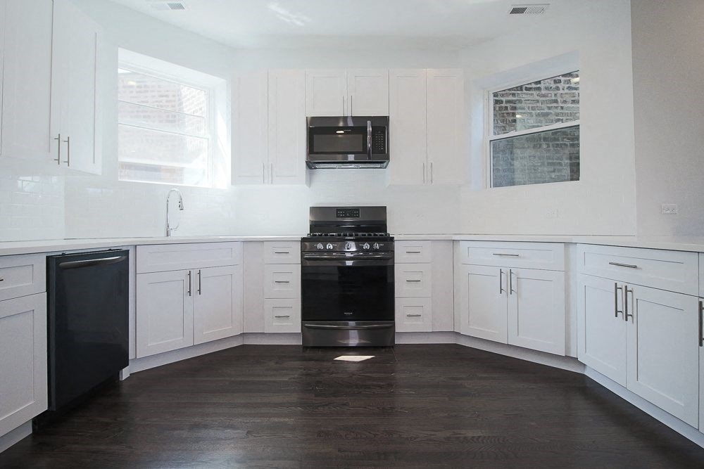 a kitchen with white cabinets and a stove and a microwave