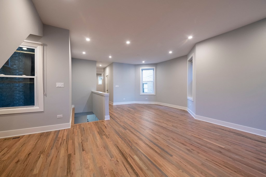 a living room with a hard wood floor and a window