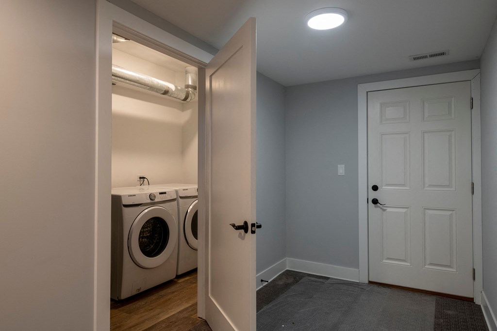a laundry room with a washer and dryer and a white door