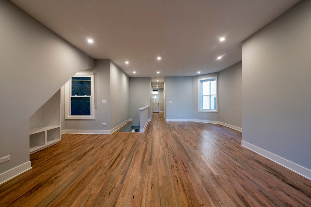 the living room and dining room of a new home with wood floors and white walls