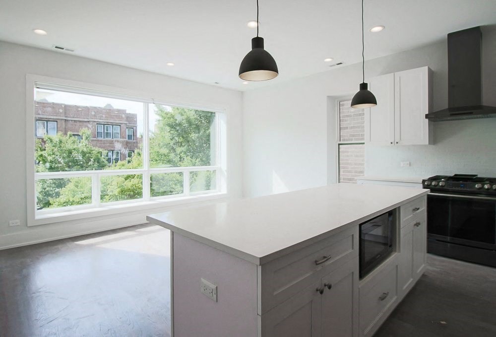 a large white kitchen with a large window