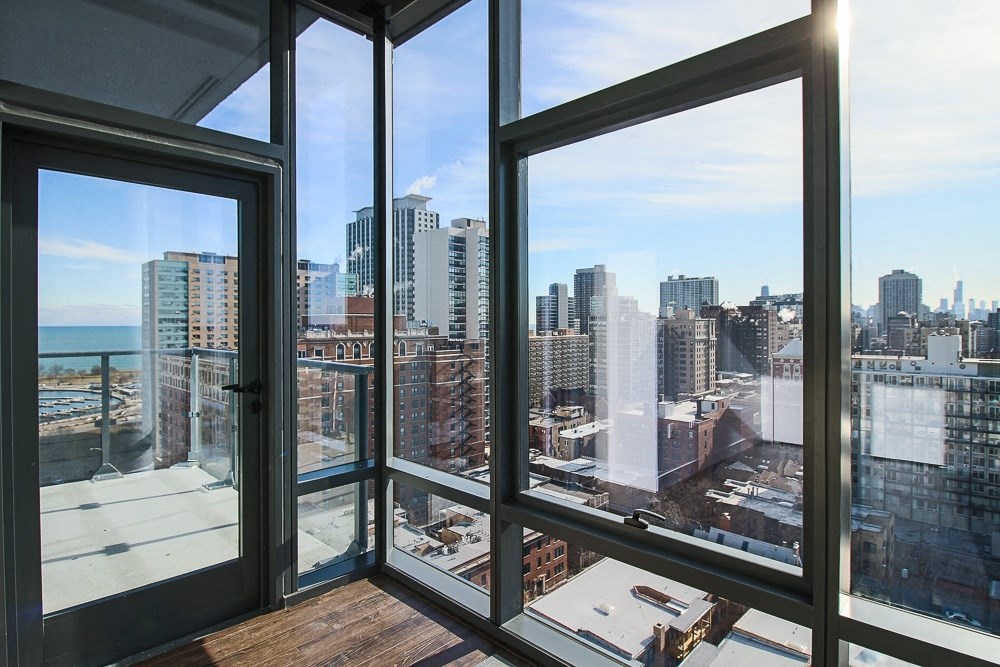 the view of the city from the living room of a condo with large windows