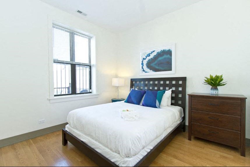 a bedroom with a bed and a dresser and a window