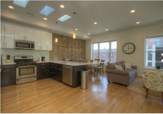a large living room with a kitchen and a table