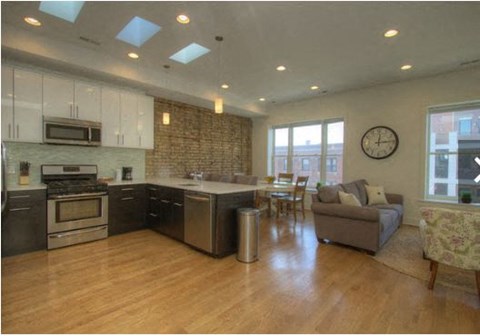 a large living room with a kitchen and a table