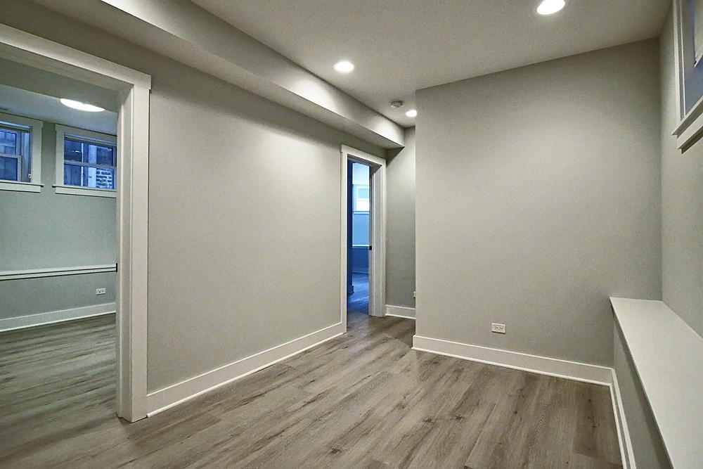 a newly renovated living room and hallway with wood flooring