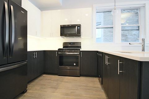 a black and white kitchen with stainless steel appliances and a window