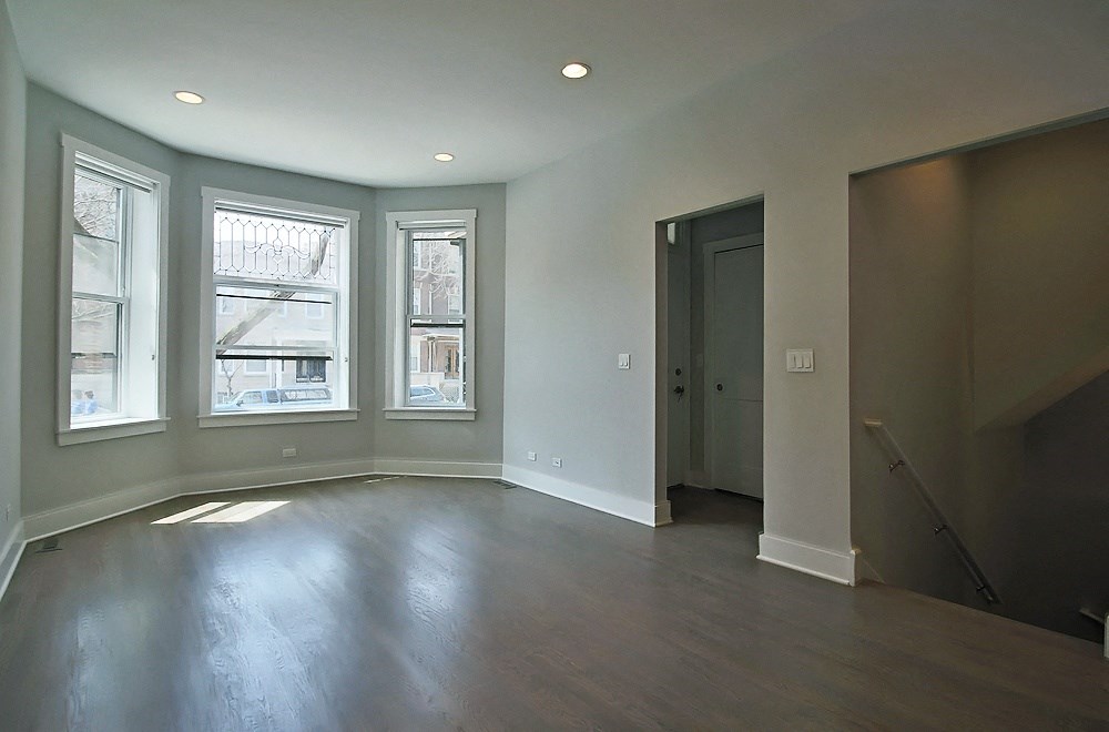 an empty living room with wood floors and windows