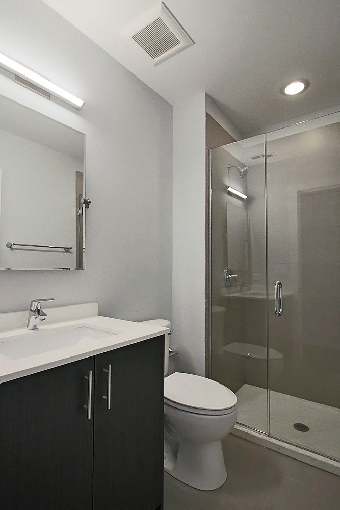 a bathroom with a shower and a sink and a toilet