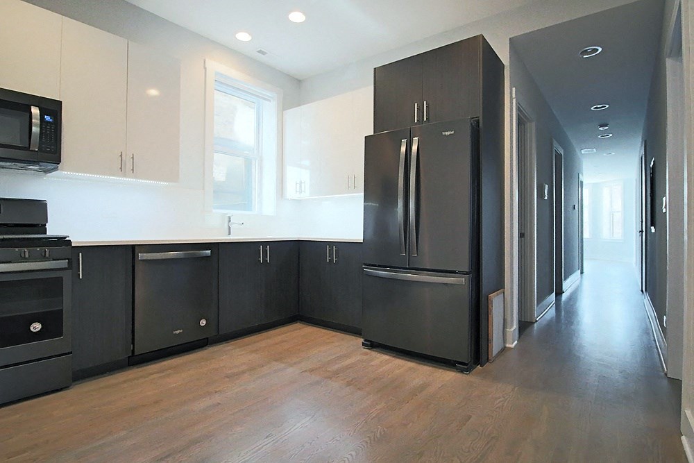 an empty kitchen with black appliances and white cabinets