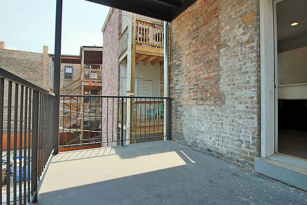 a balcony with a black railing and a brick wall