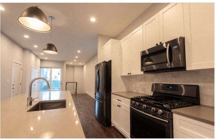 a kitchen with a stove and a sink and a microwave