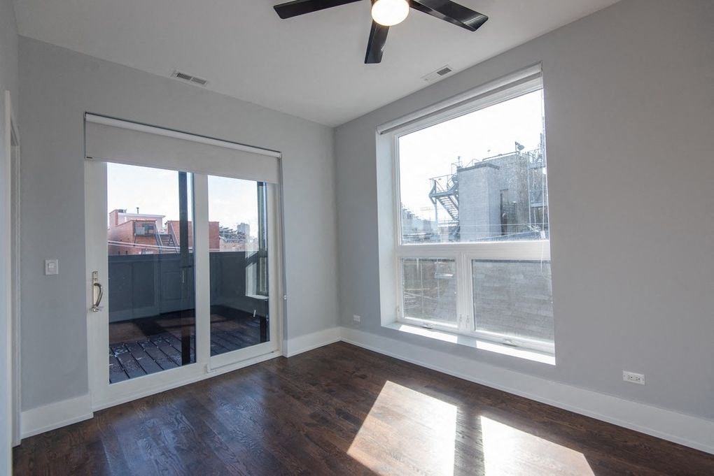 a living room with a large window and a door to a balcony
