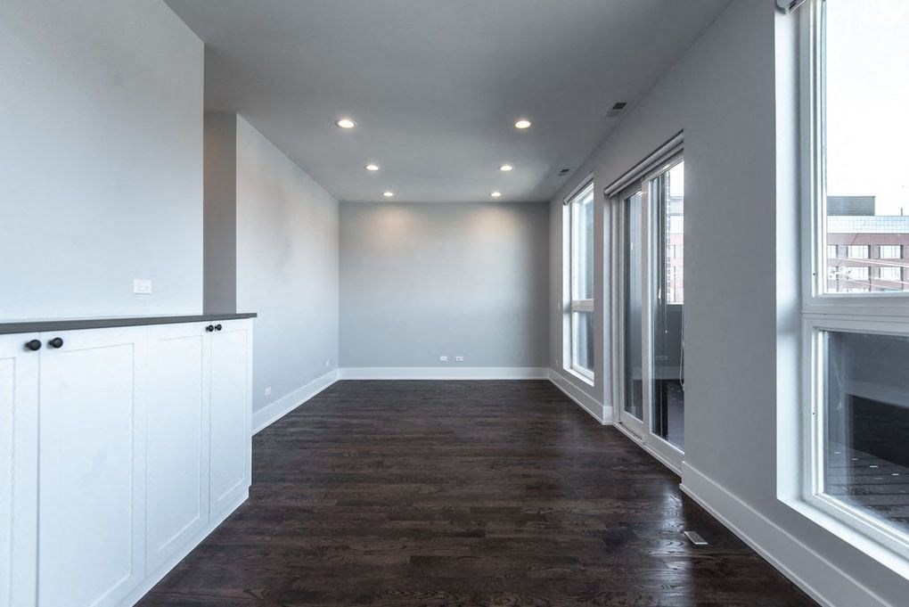 a living room with a wood floor and a large window