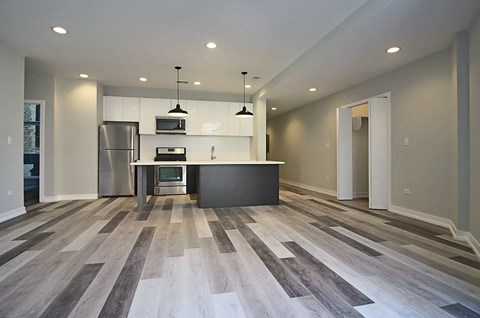 a kitchen with an island and a stainless steel refrigerator
