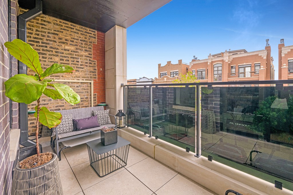 a balcony with a couch and a plant and a window