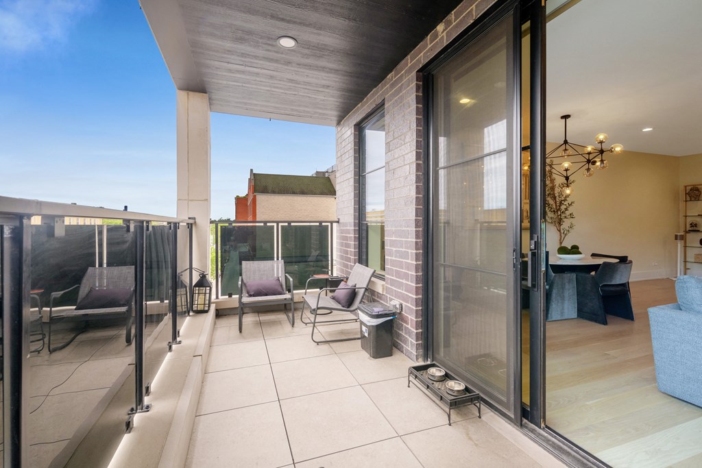 a terrace with chairs and a table and glass doors