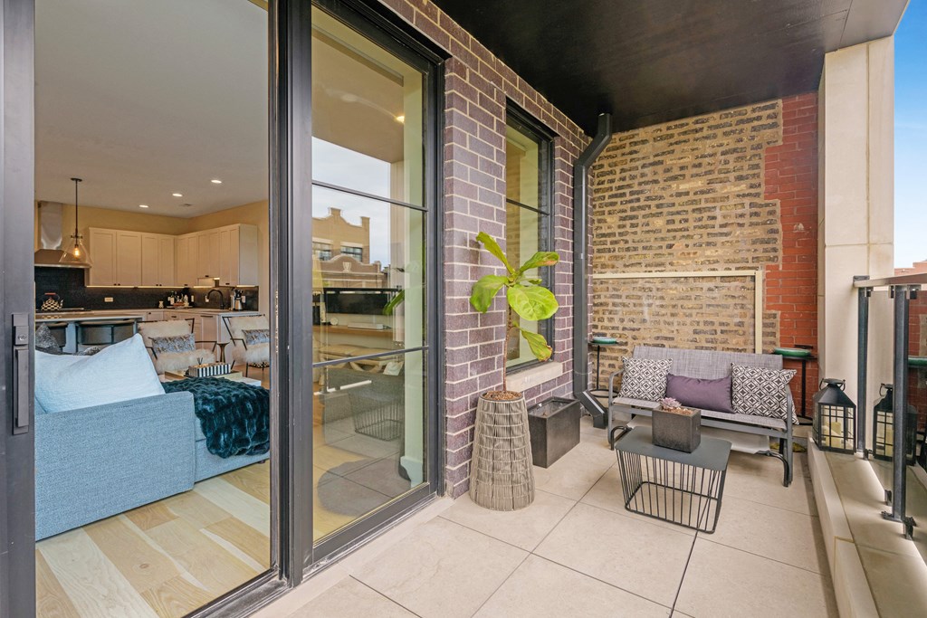 a patio with a couch and a table and sliding glass doors
