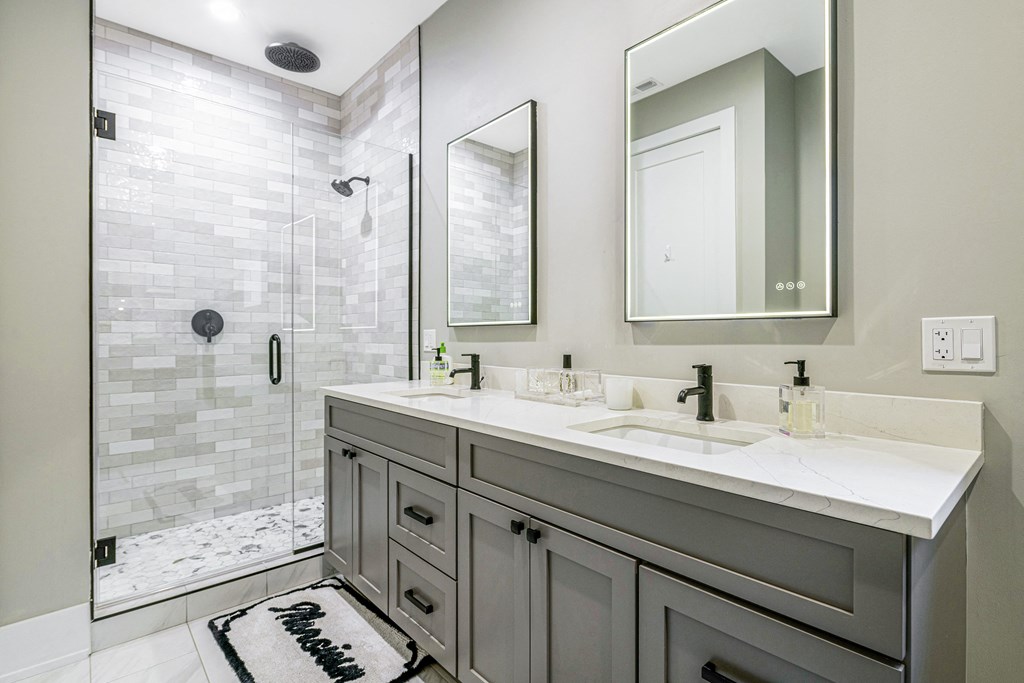 a bathroom with two sinks and a shower