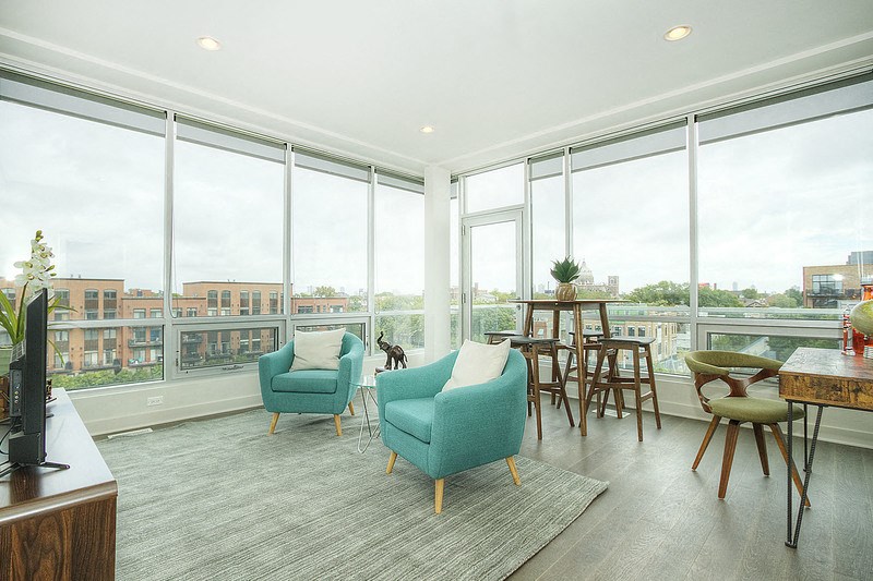 a living room with large windows and a view of a city