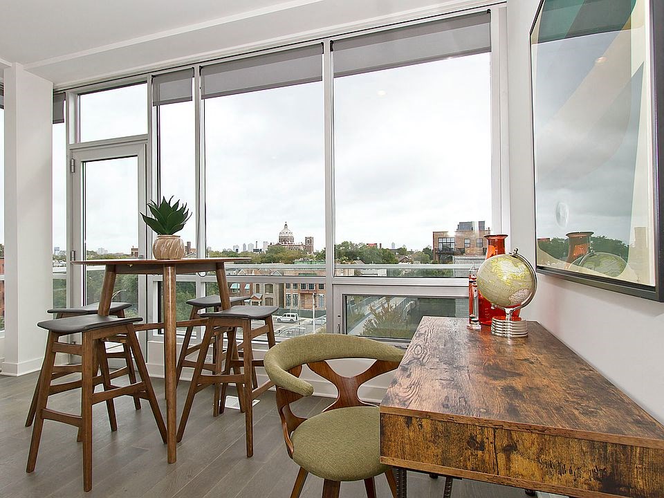 a living room with a wooden table and chairs and a balcony