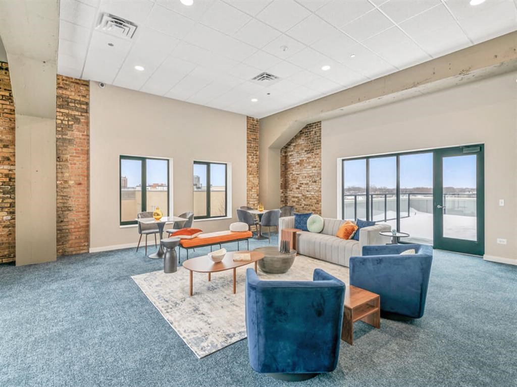 a large living room with couches and tables and windows