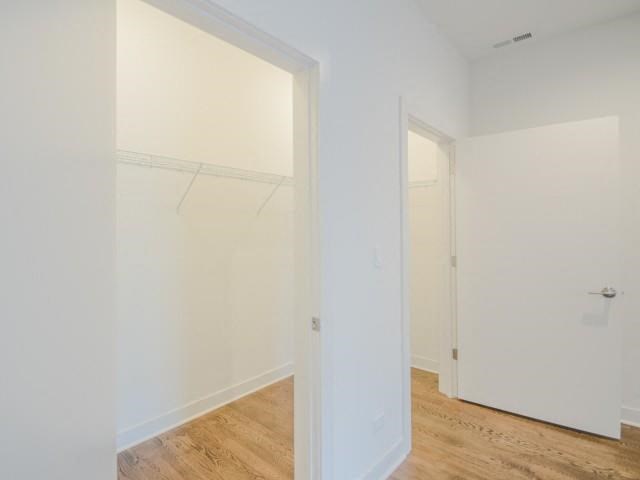 an empty bedroom with white walls and a wood floor