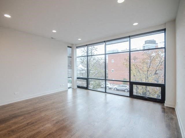 an empty living room with a large window and wood floors