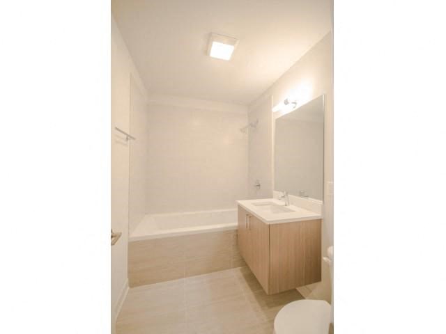 a bathroom with a sink and a tub and a mirror