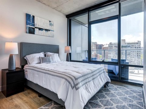 a bedroom with a bed and a large window