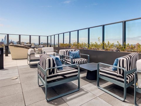 a lounge area with chairs and tables on a balcony