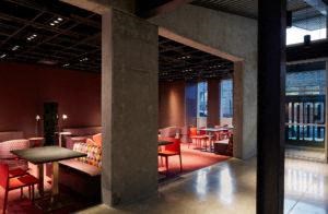 a restaurant with red chairs and tables in a lobby