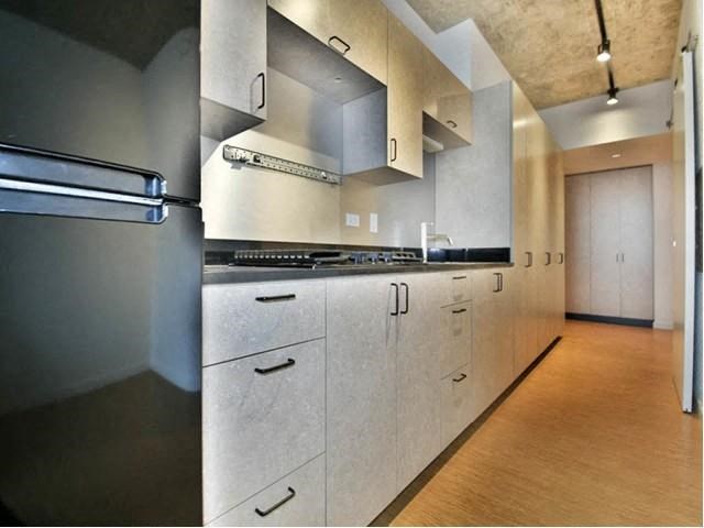 a kitchen with white cabinets and a stainless steel refrigerator