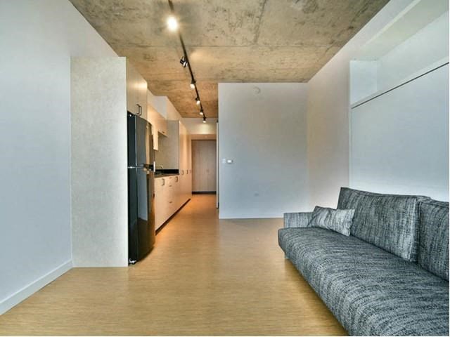 a living room with a couch and a kitchen