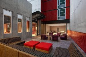 a living room with red couches and a table and chairs