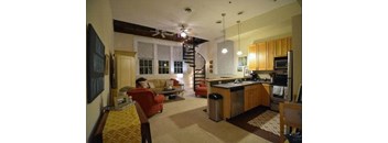 a living room filled with furniture and a kitchen