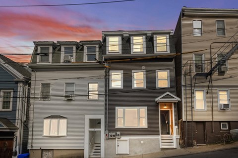 A row of houses with a red sky in the background.
