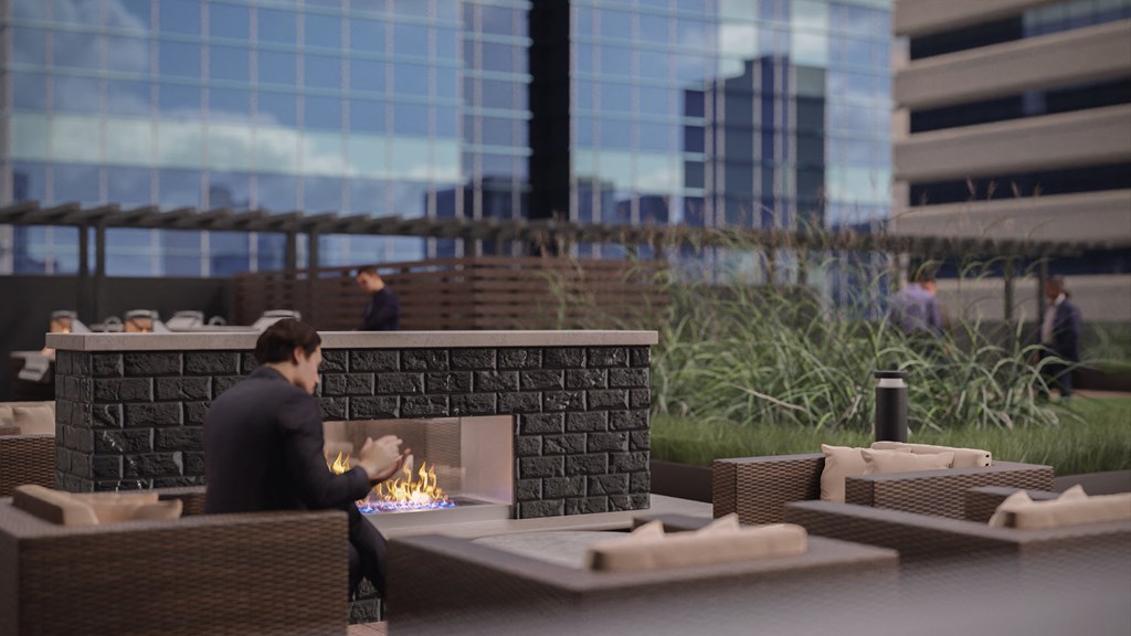 a man sitting in front of a fireplace on the patio of a building