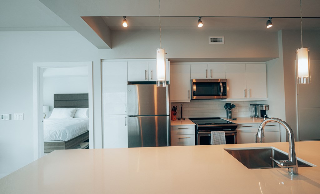 a kitchen with white cabinets and stainless steel appliances