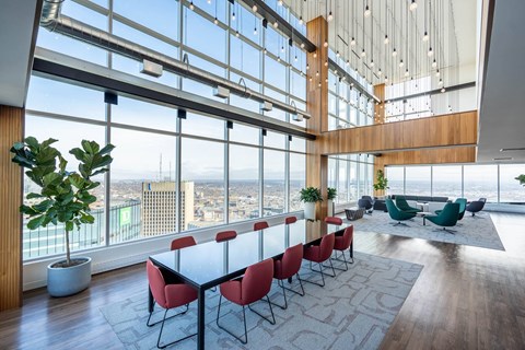 A conference room with a long table and chairs with a view of the city outside the window.