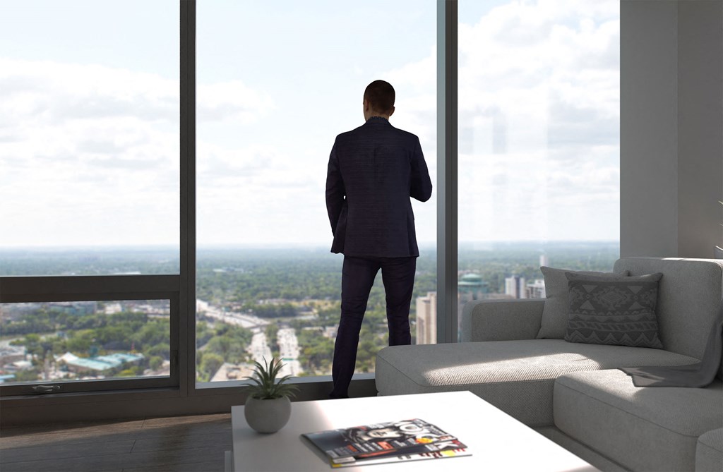 a man in a suit standing in a living room looking out of a window