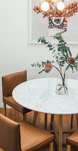 a dining room table with a vase of flowers on it
