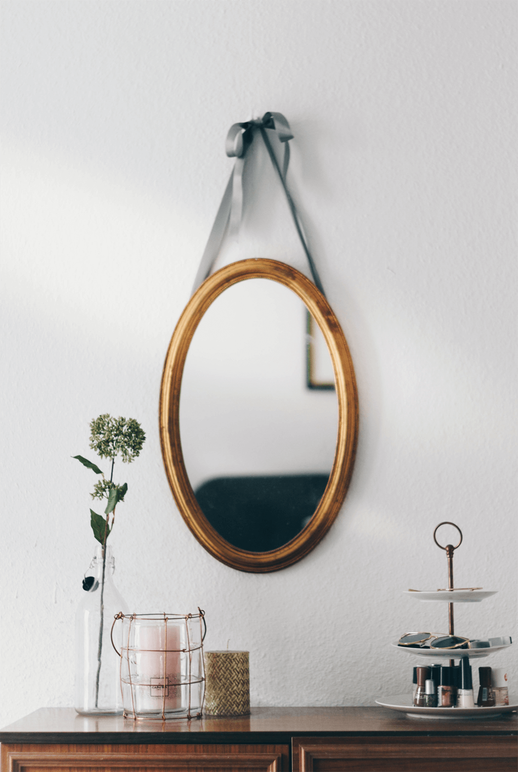 a round wooden mirror on a white wall