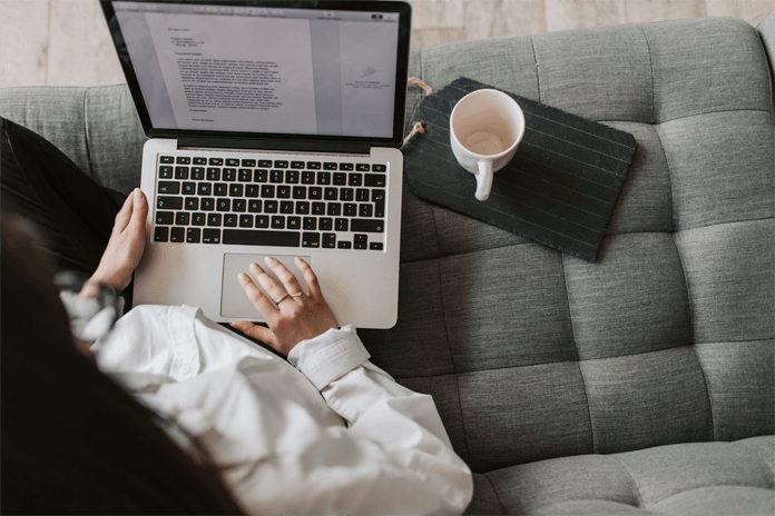 a woman sitting on a couch using a laptop computer