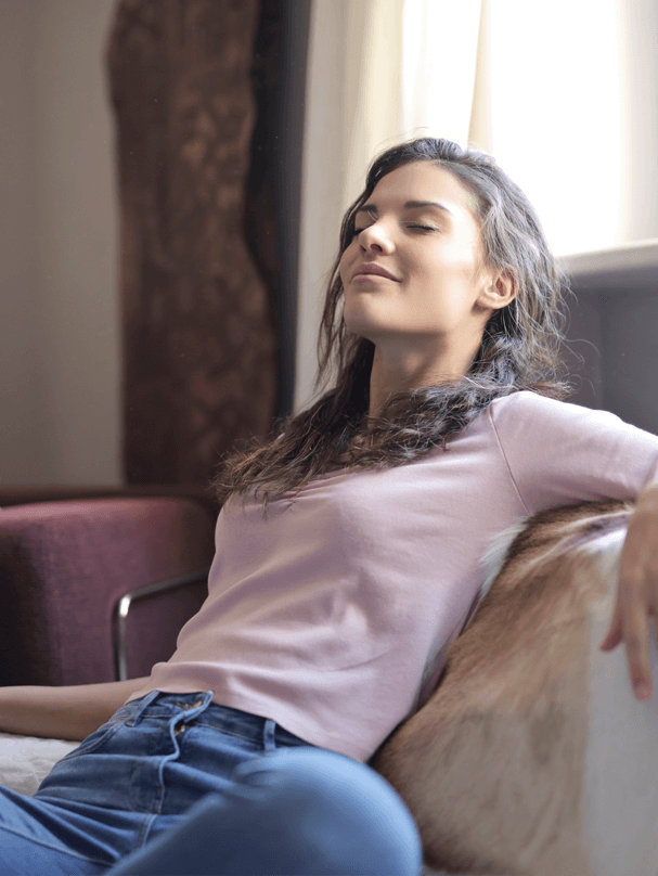 a woman sitting on a bed with her eyes closed