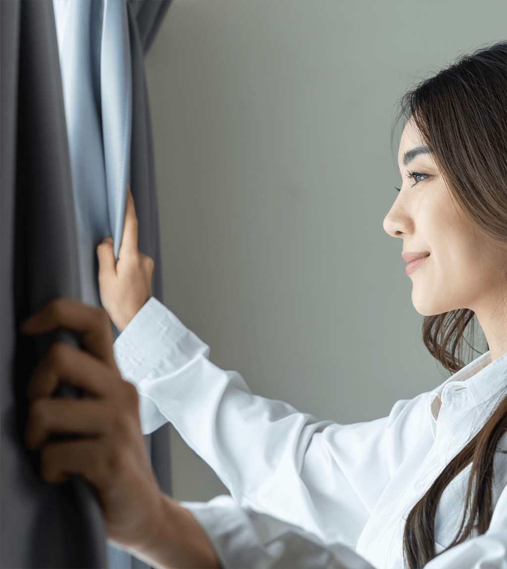 a woman in a white shirt opens a window