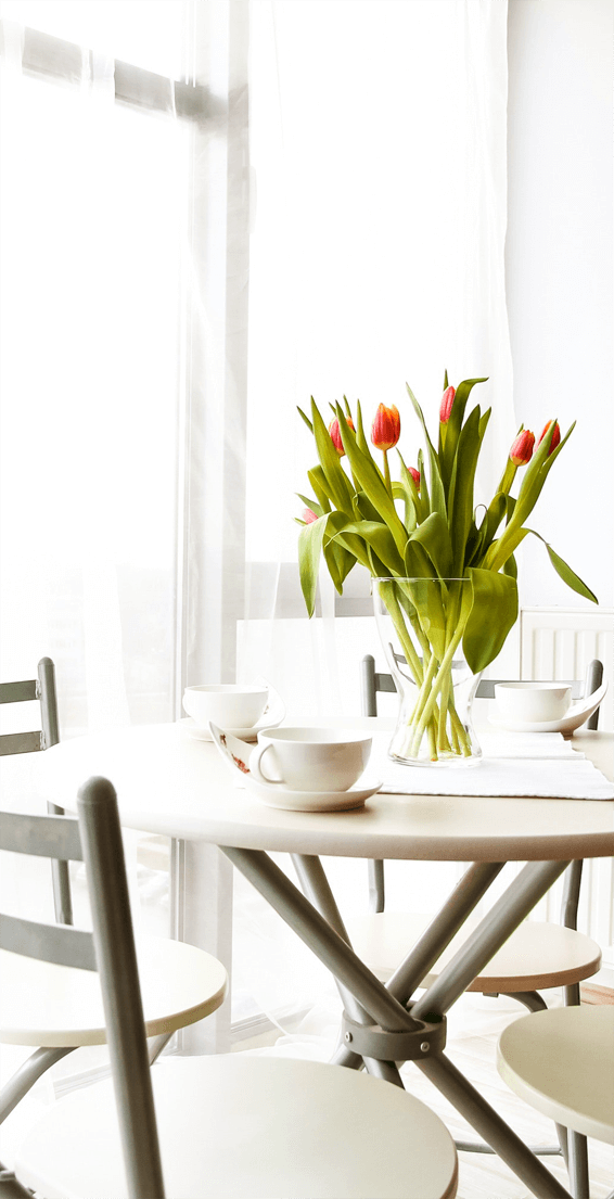 a table with a vase of tulips on it