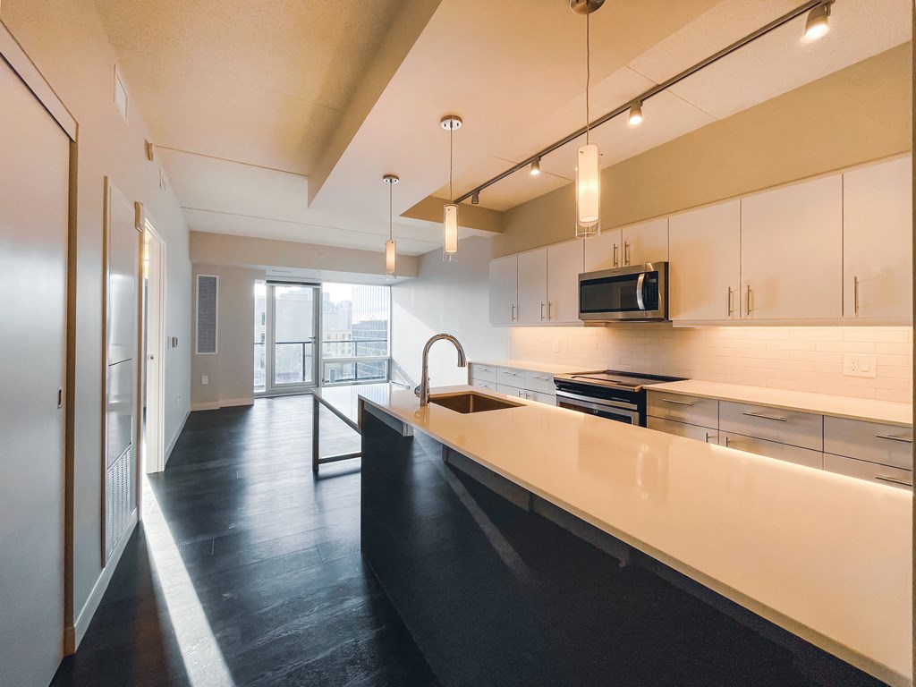 a large kitchen with white cabinets and a black counter top